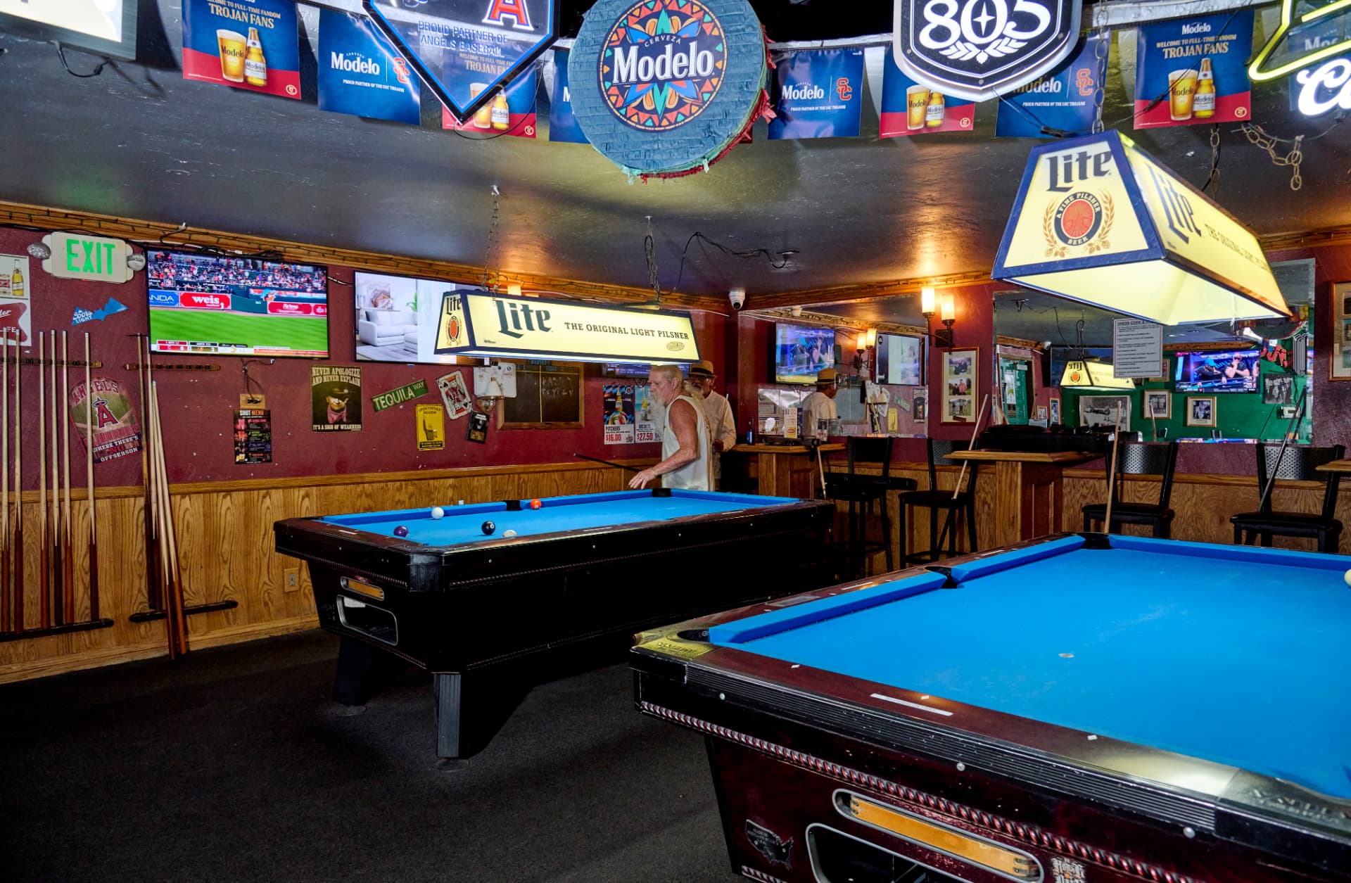 Pool tables under Miller Lite lamps in Harvey's back room